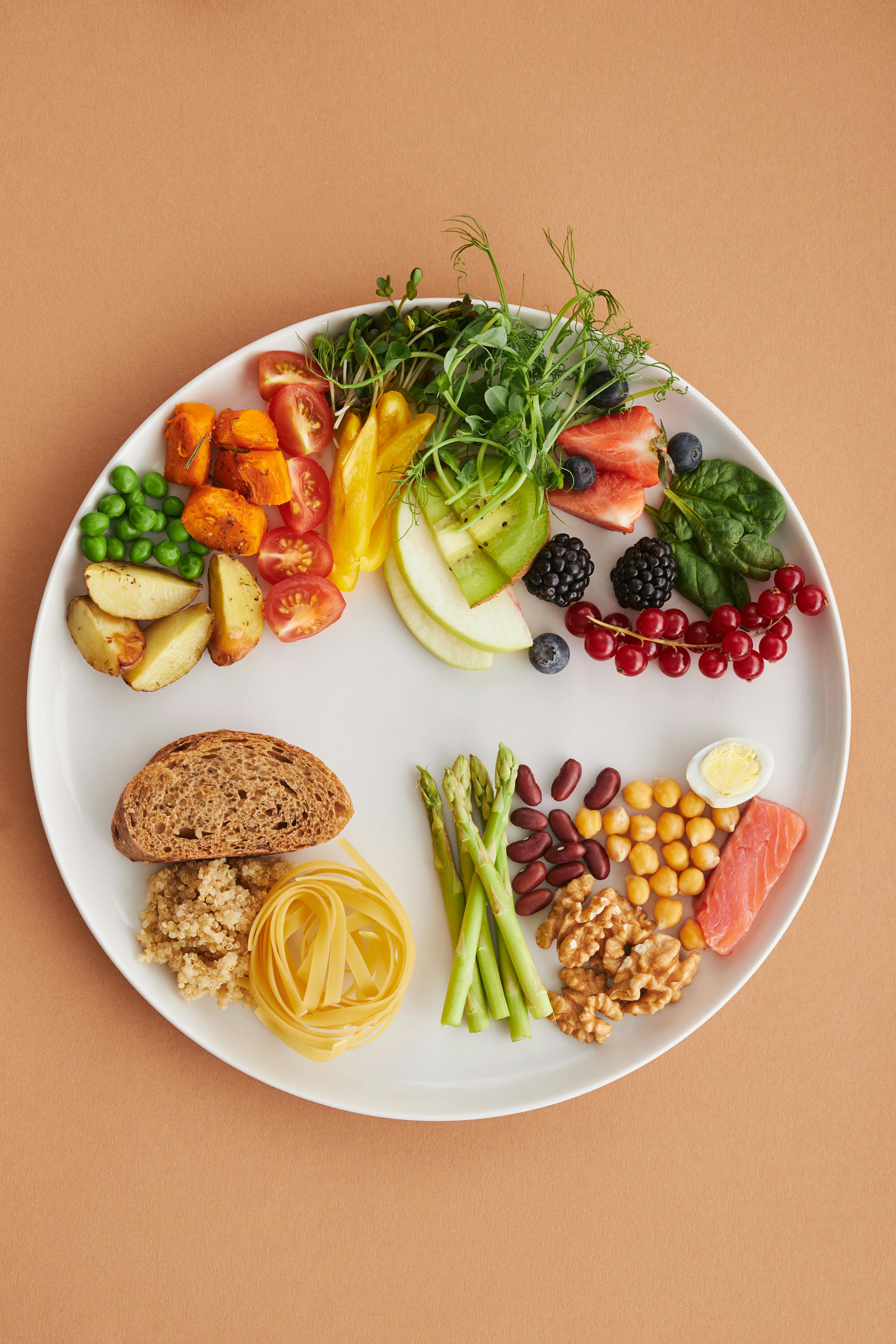 A vibrant flat lay of fresh fruits, vegetables, grains, and proteins, arranged in synergistic groups.